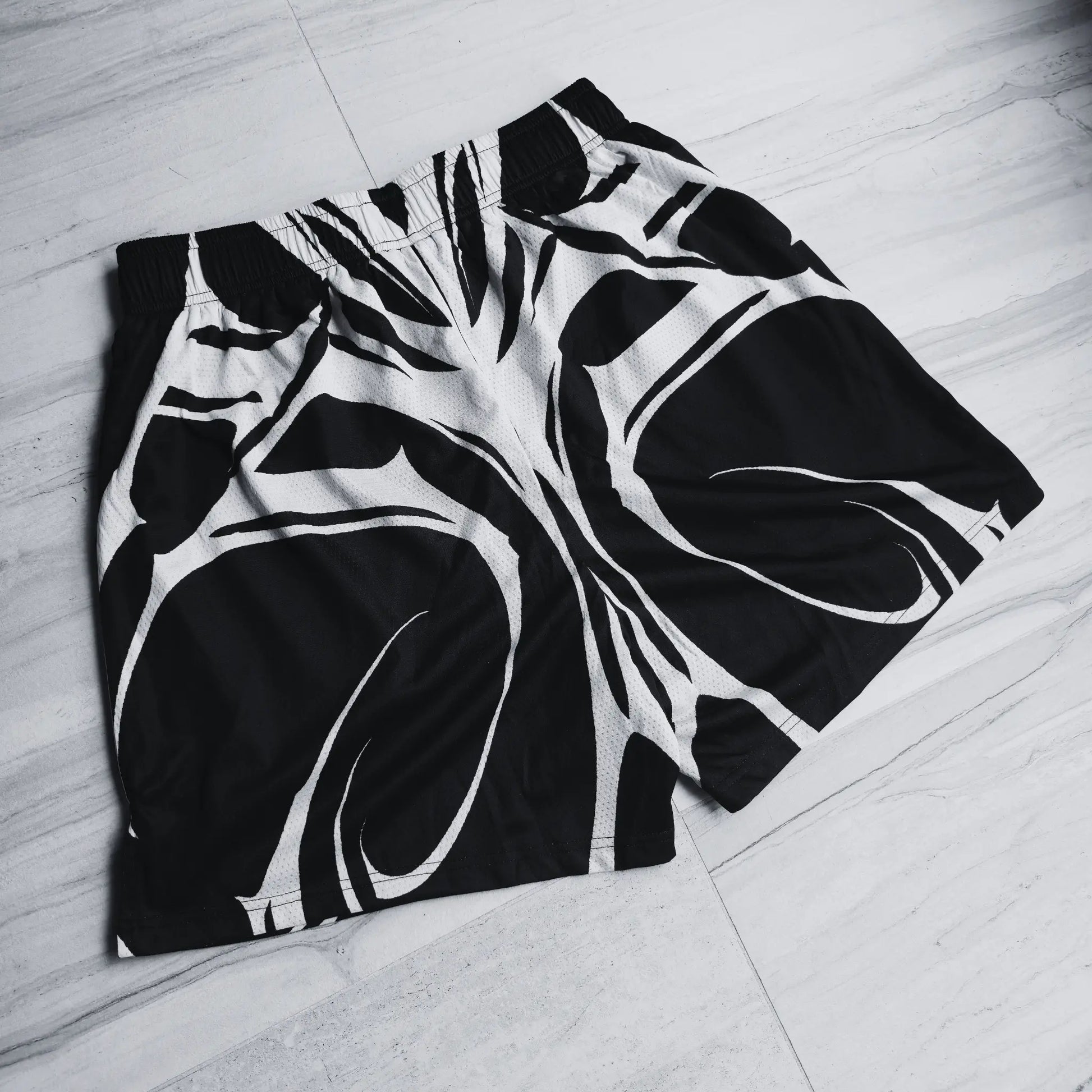 Black and white patterned shorts on a light wooden floor