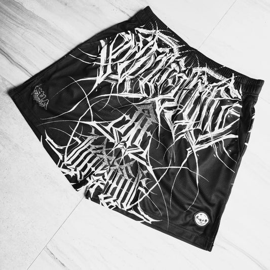 Black shorts with white abstract pattern on a light wooden floor