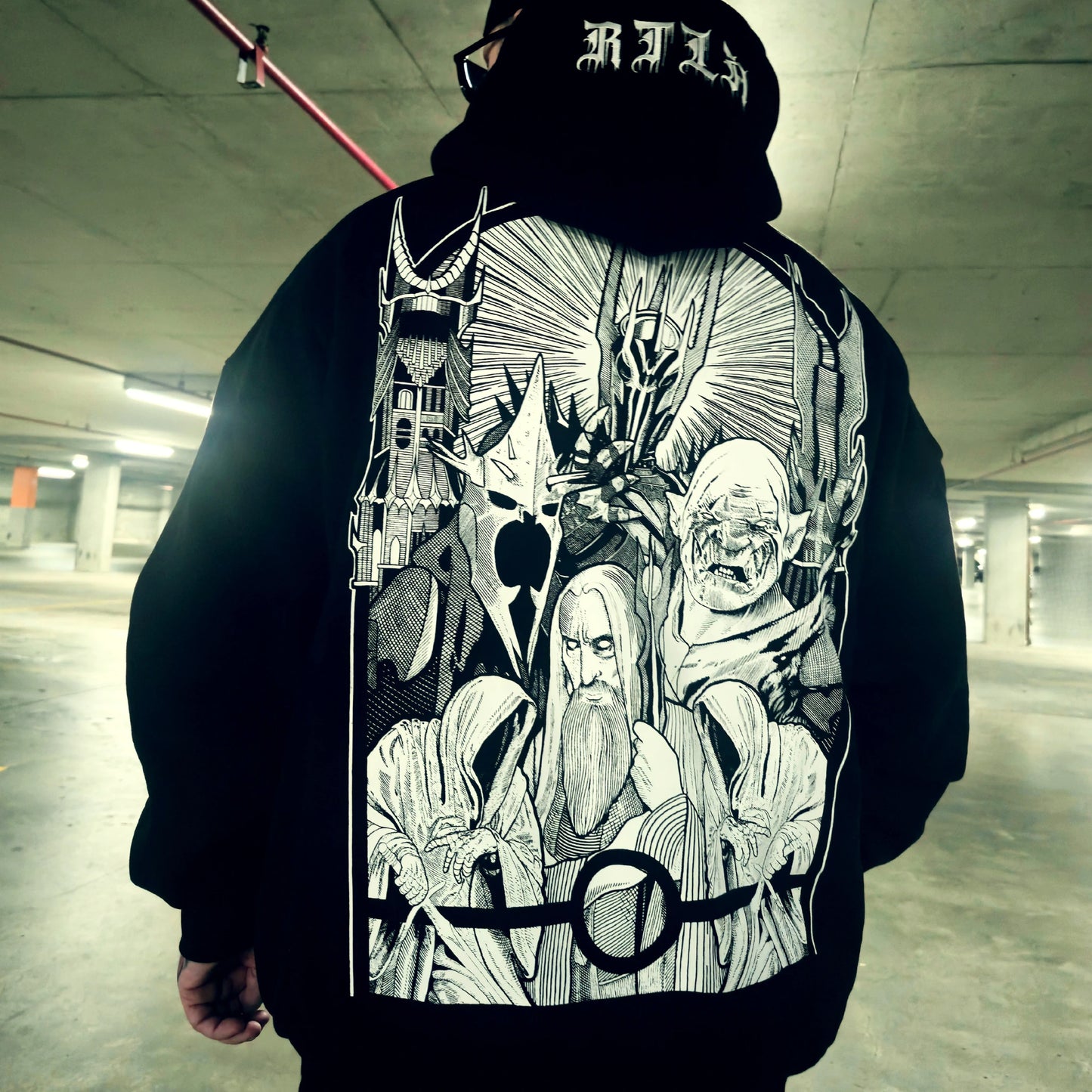 Person wearing a hoodie with a detailed graphic design in an indoor setting