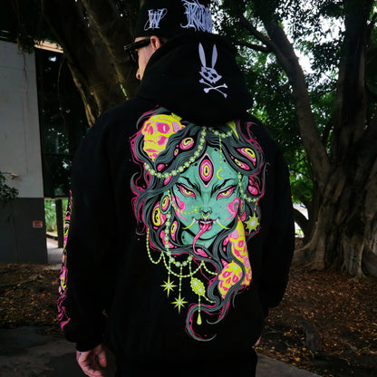 Person wearing a black hoodie with a colorful graphic design outdoors.