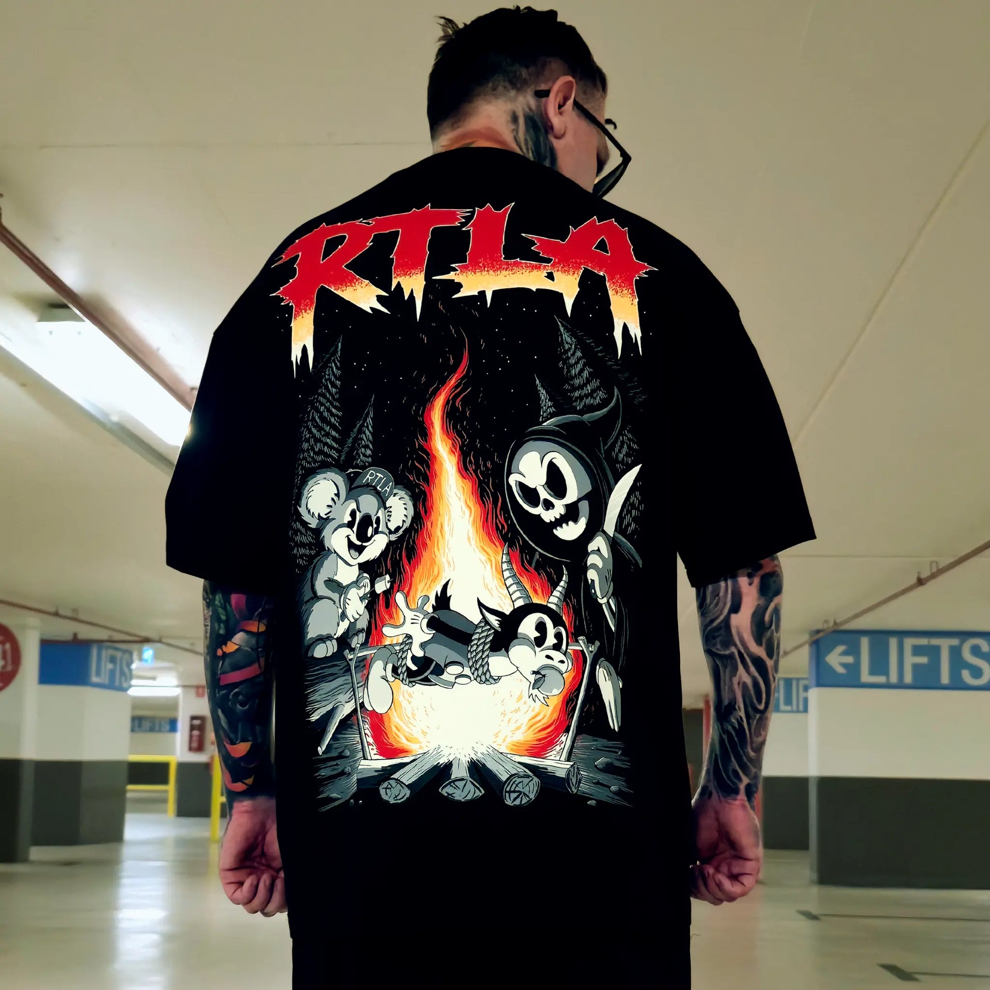 Person wearing a black t-shirt with graphic design and 'RTLA' text in an indoor setting.