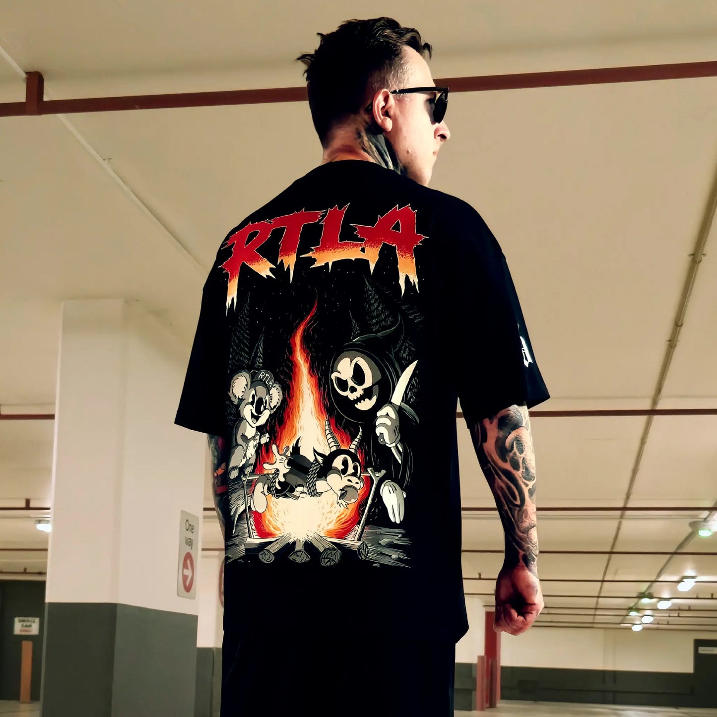 Person wearing a black t-shirt with a graphic design and 'RTLA' text in an indoor setting.