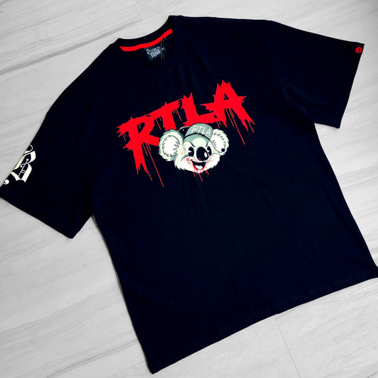 Black t-shirt with a graphic design of a koala and red text on a light wooden floor.
