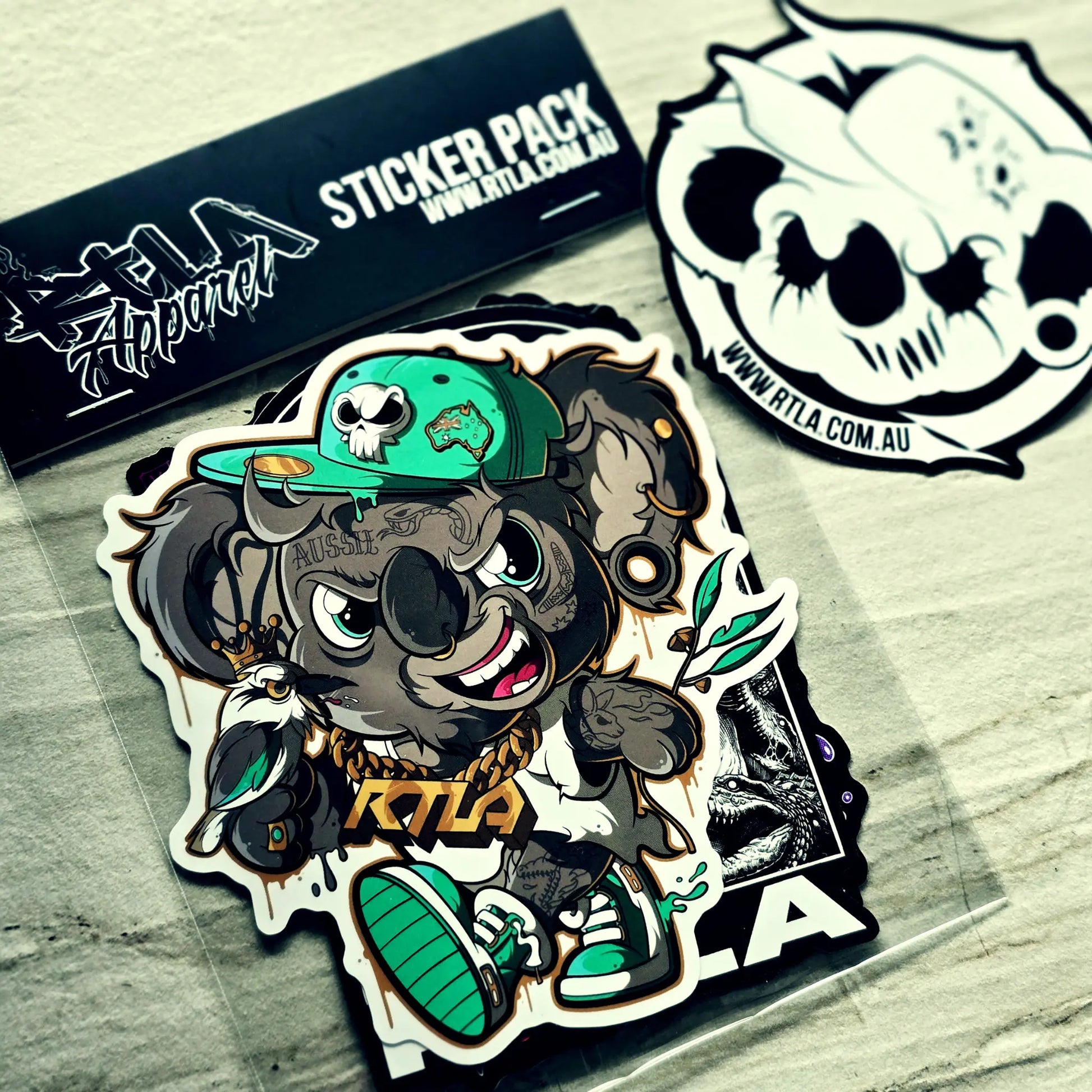 Sticker pack with a stylized animal character wearing a green cap and 'RTLA' branding on a textured surface.