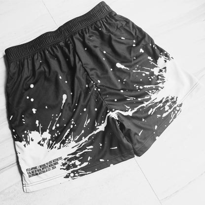 Black shorts with white splatter design on a light gray background