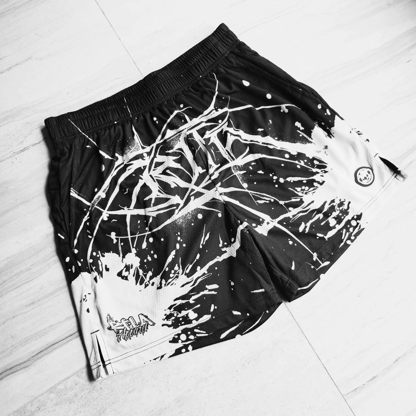 Black shorts with white abstract design on a light wooden floor