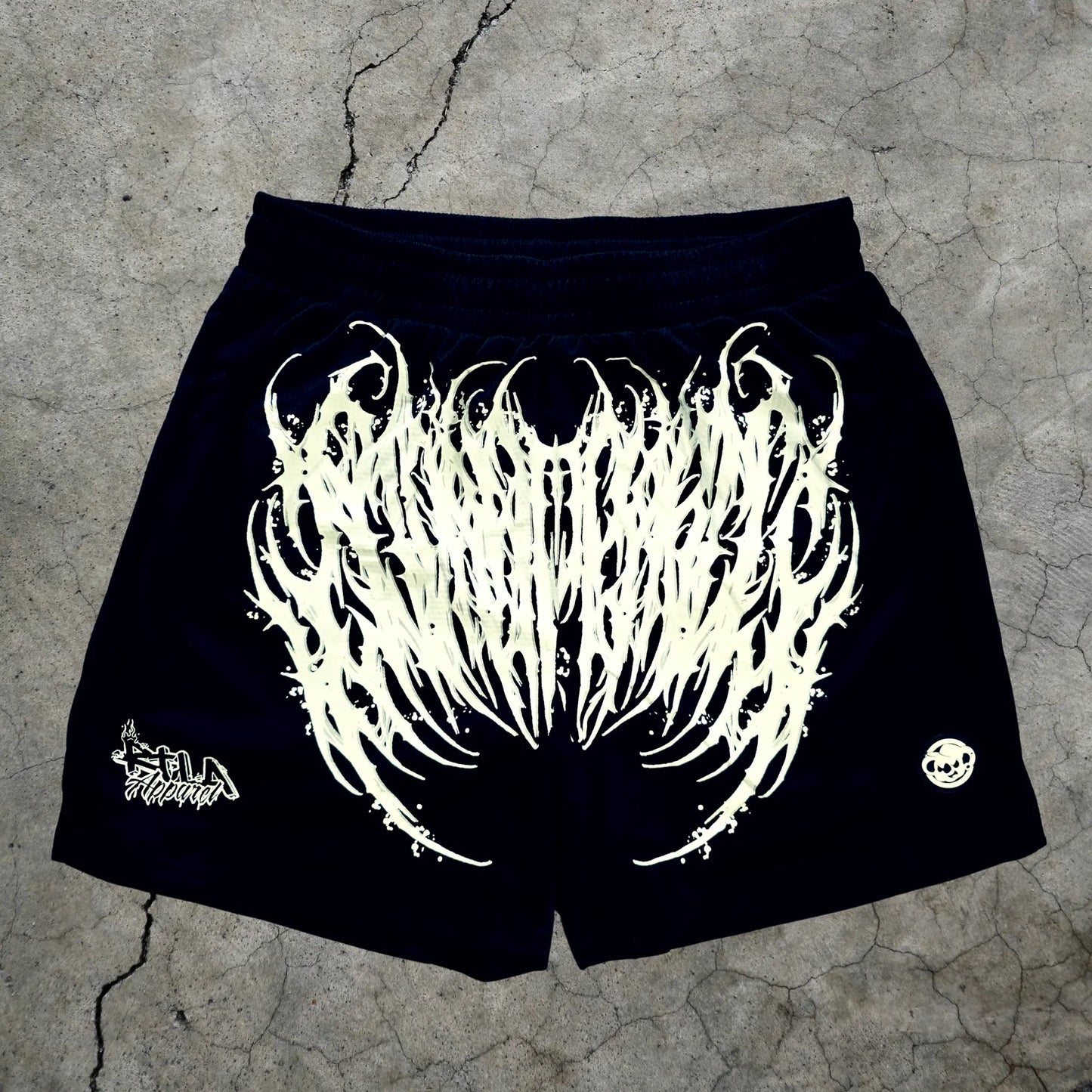 Black shorts with white graphic design on a textured surface