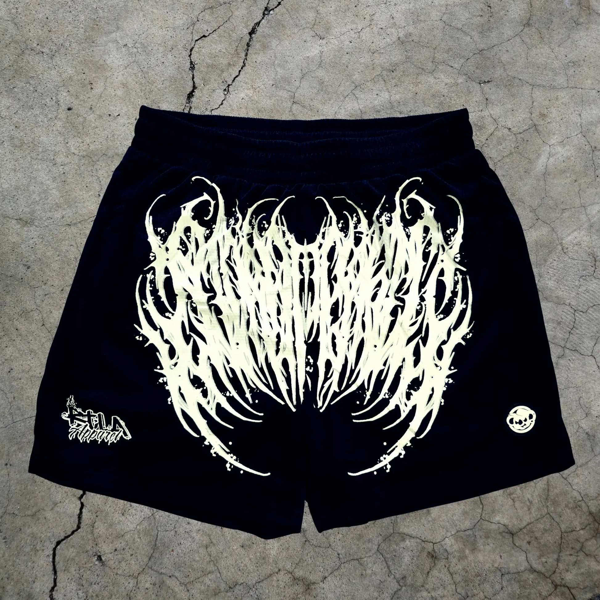 Black shorts with white graphic design on a textured surface
