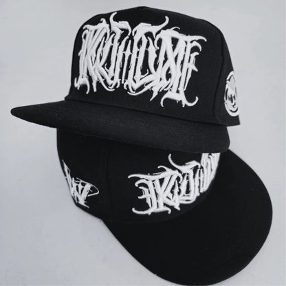 A black snapback cap with white 3D embroidered lettering on the front and a logo on the side. RTLA Apparel