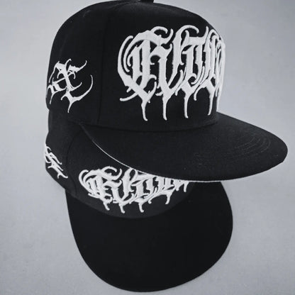 A black snapback cap with white 3D embroidered lettering and an artist signature logo on the side. RTLA-Apparel