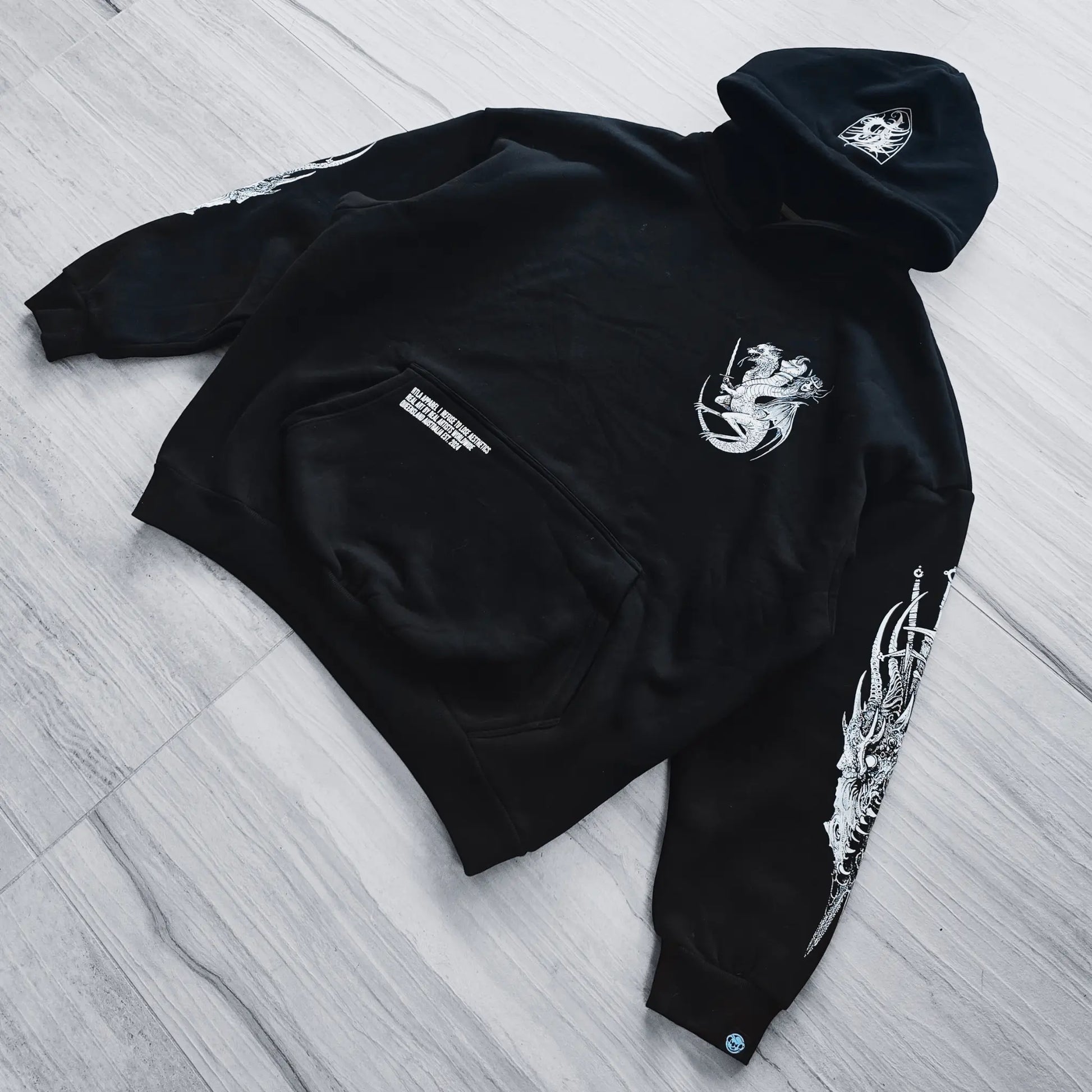 Black hoodie with white designs on a wooden floor