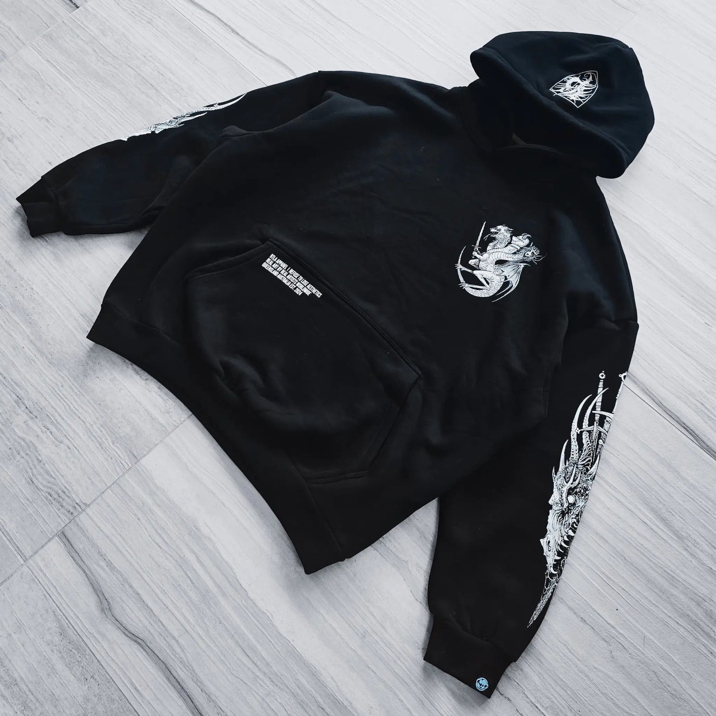 Black hoodie with white designs on a wooden floor