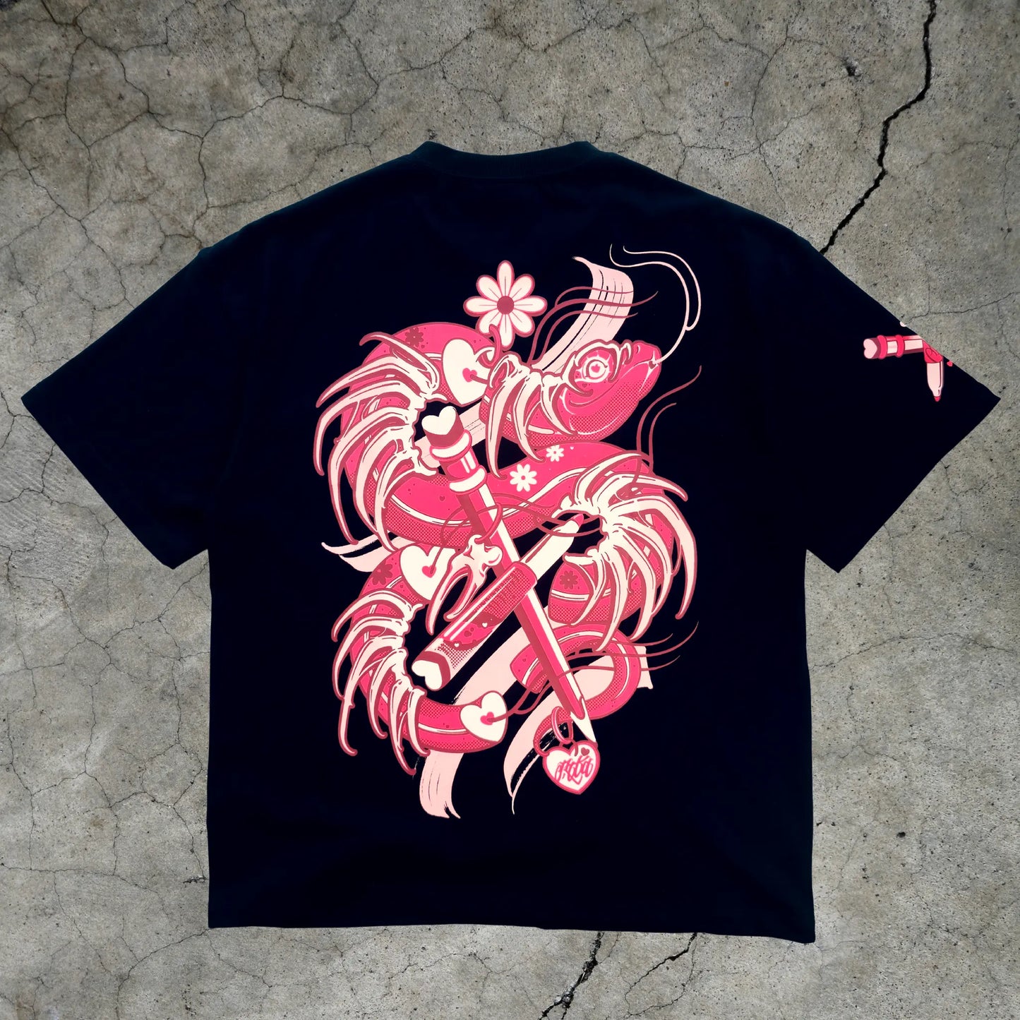 Black t-shirt with pink and white graphic design on a textured gray surface
