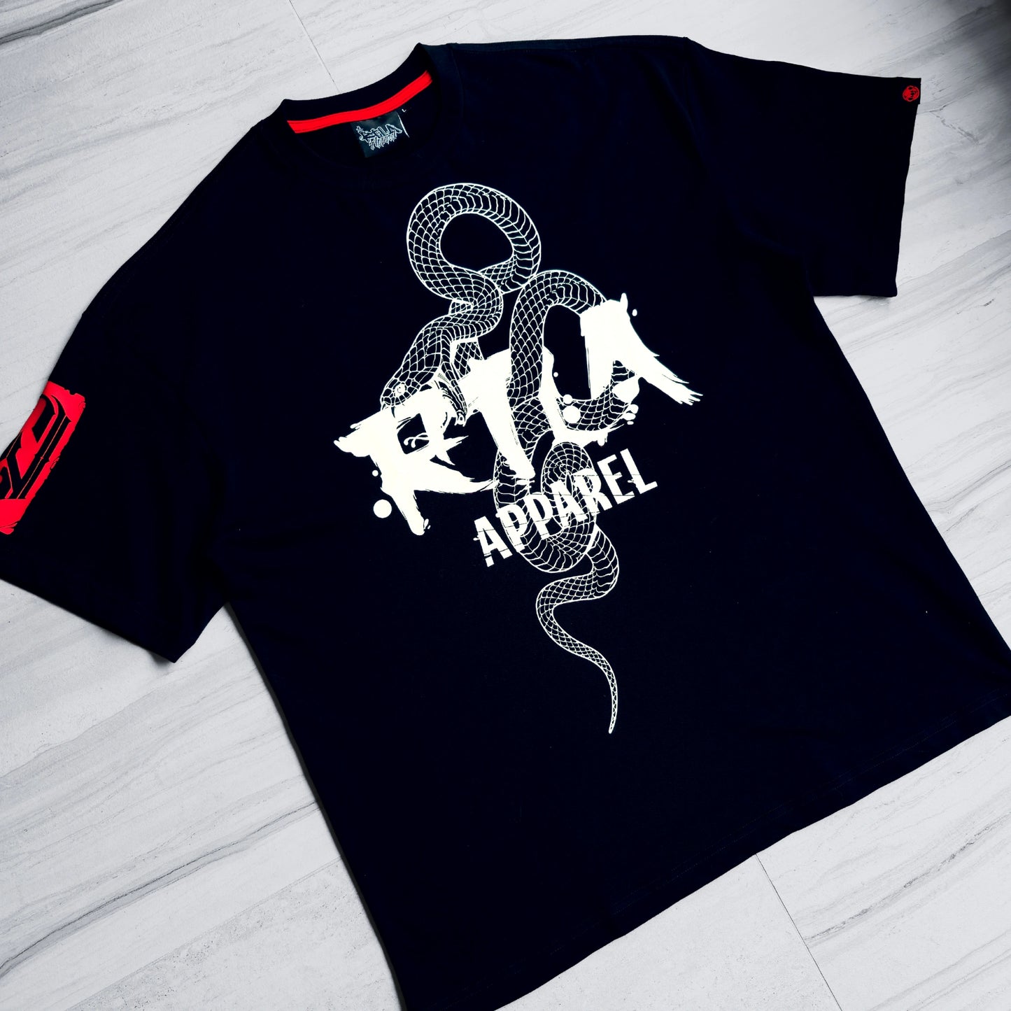 Black t-shirt with white graphic design and red accents on a light gray surface